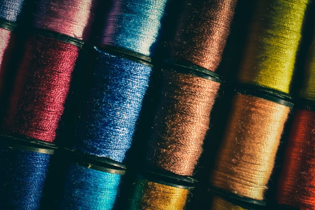 A detailed photo showcasing various colorful thread spools neatly stacked, highlighting their vivid hues.